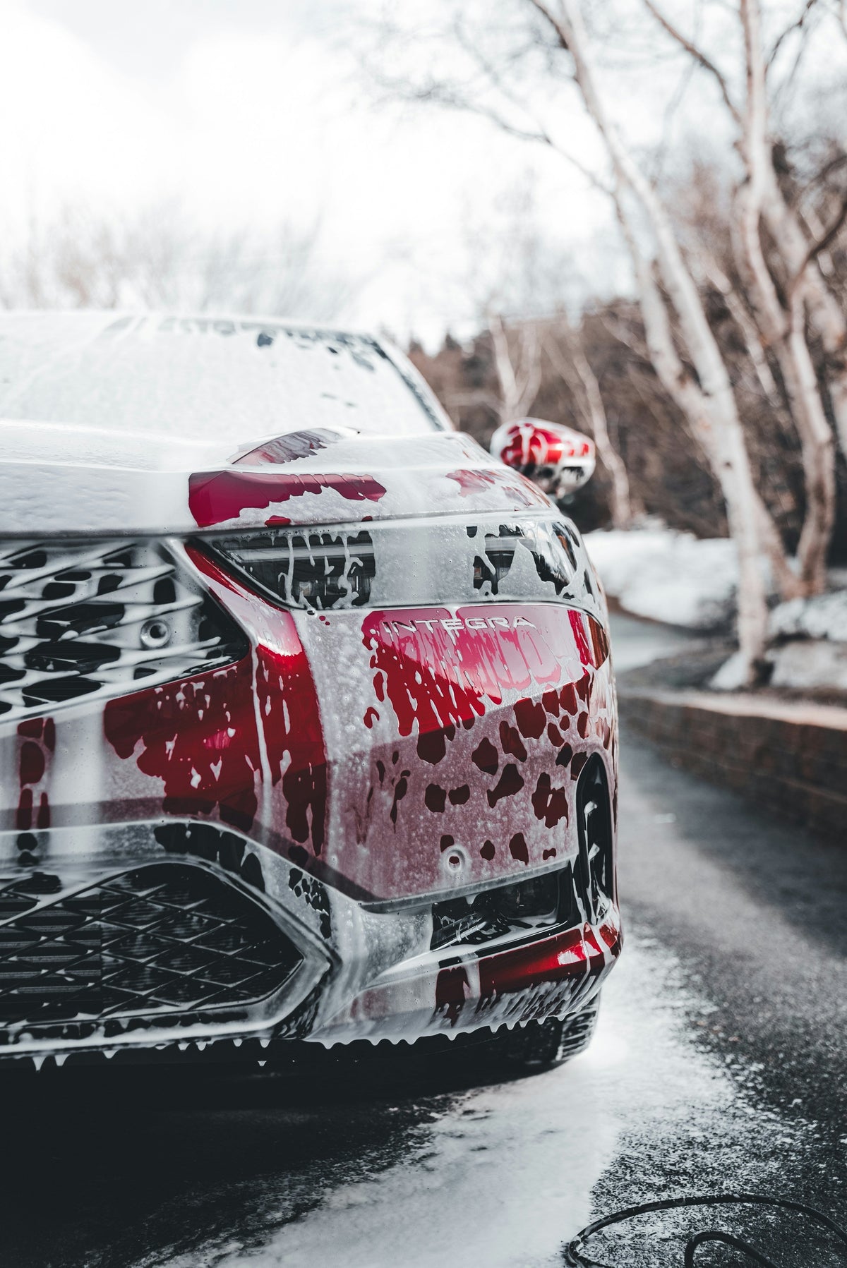 Car wash soap being used to clean a car with foam