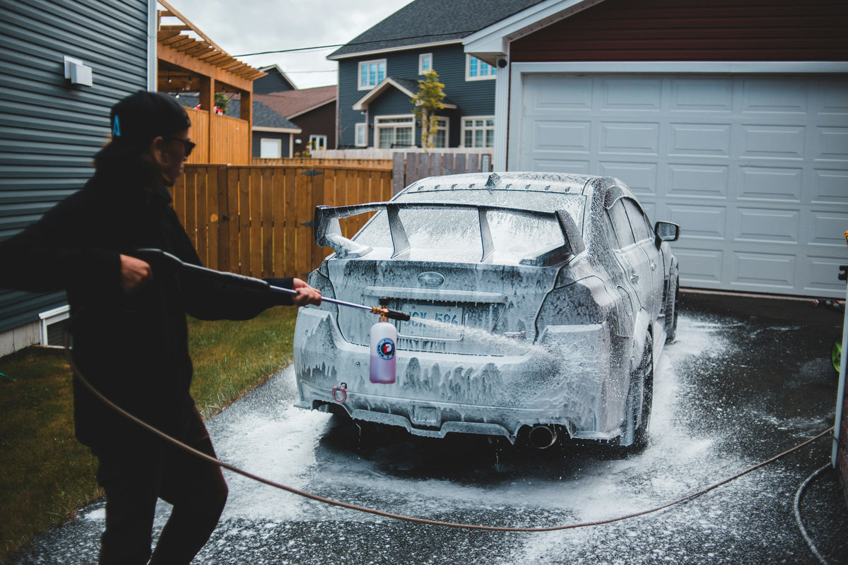 Foam cannon spraying thick foam onto a car during wash