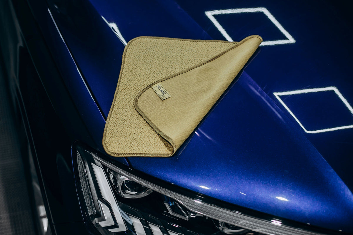 Drying towel removing water from a car surface after washing