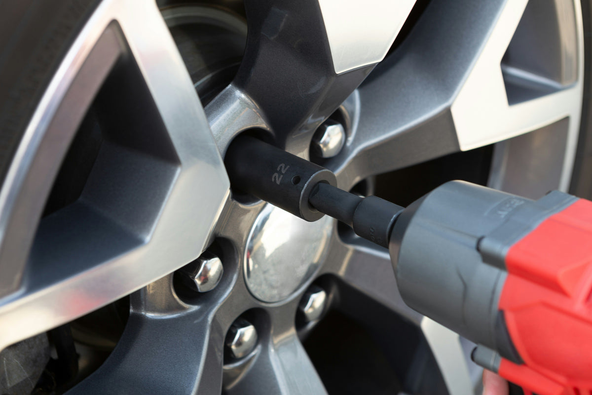 Impact wrench loosening lug nuts on a car wheel